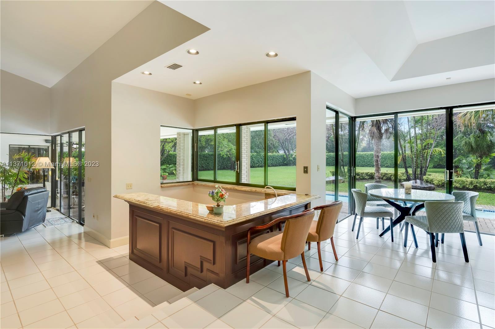 Beautiful wet bar with seating area, perfectly positioned to be at the center of the house!