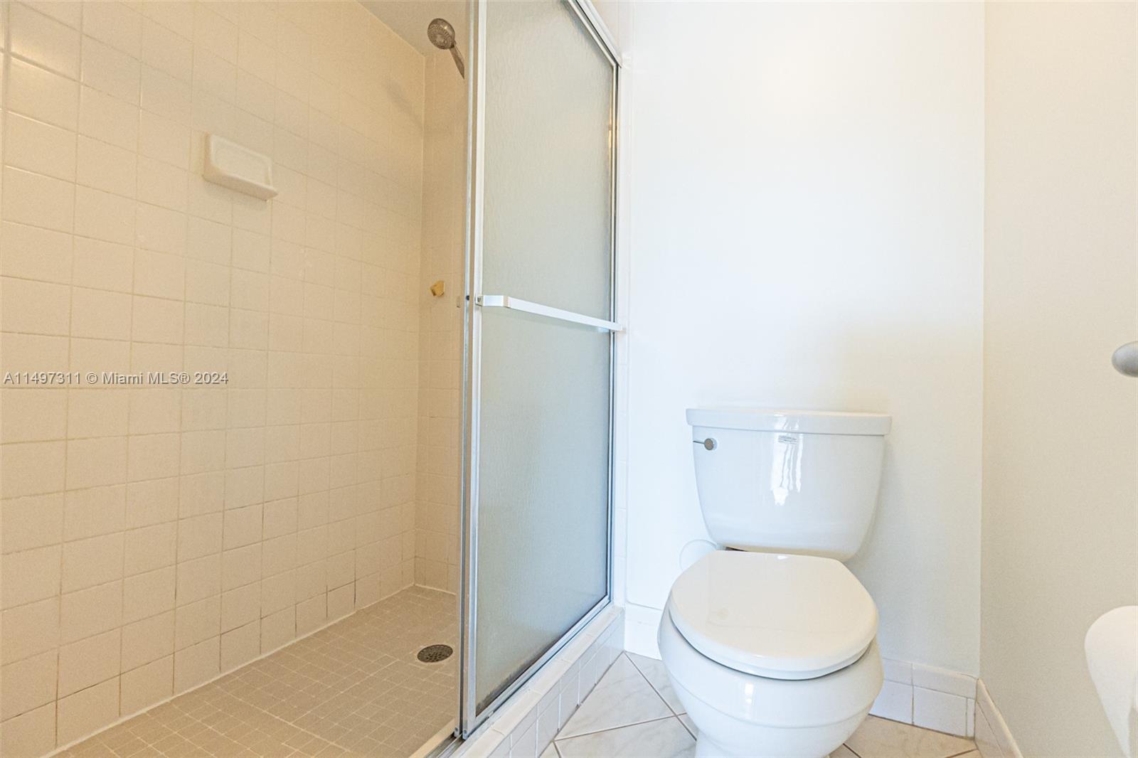 Ensuite Bathroom Shower & Toilet w/ Privacy Pocket Door in Master Bedroom