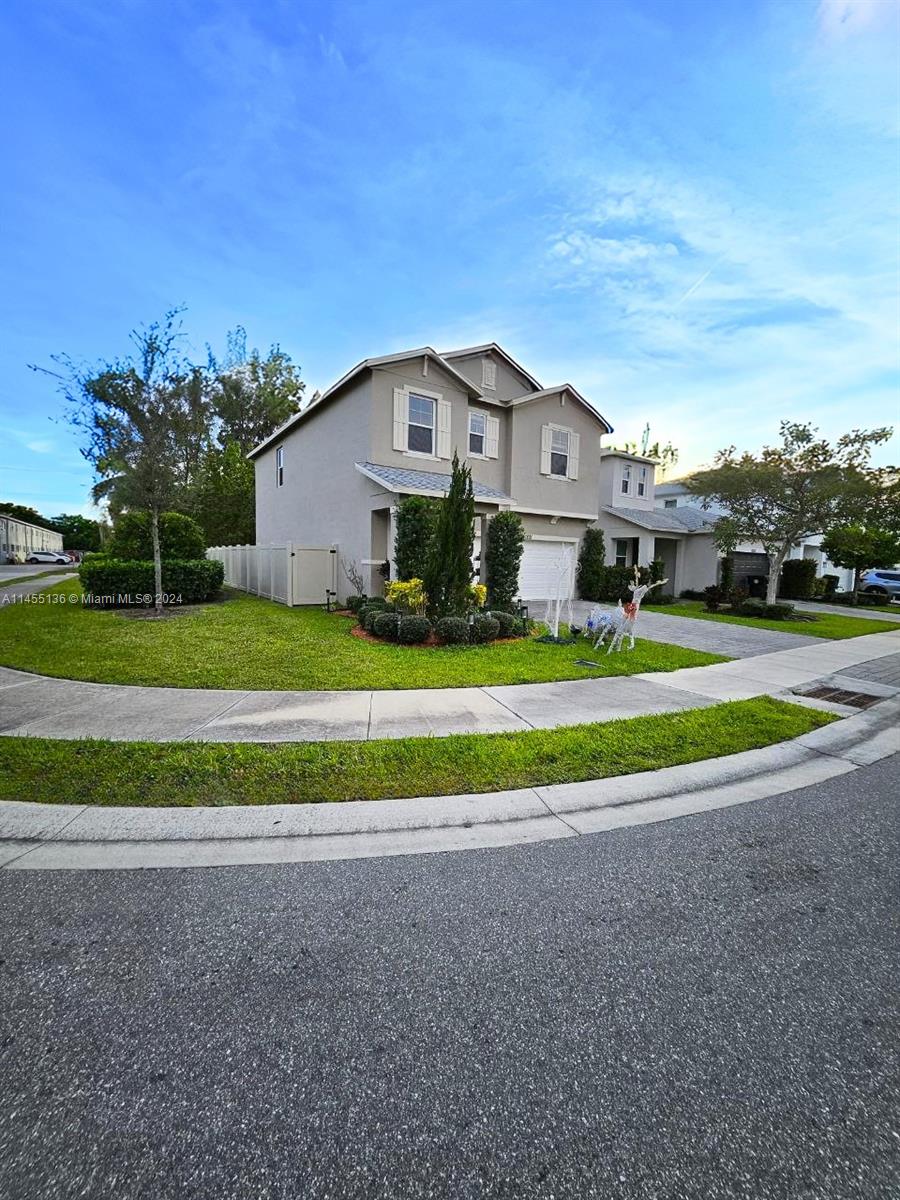A meticulously maintained and lush front yard greets you with vibrant greenery.