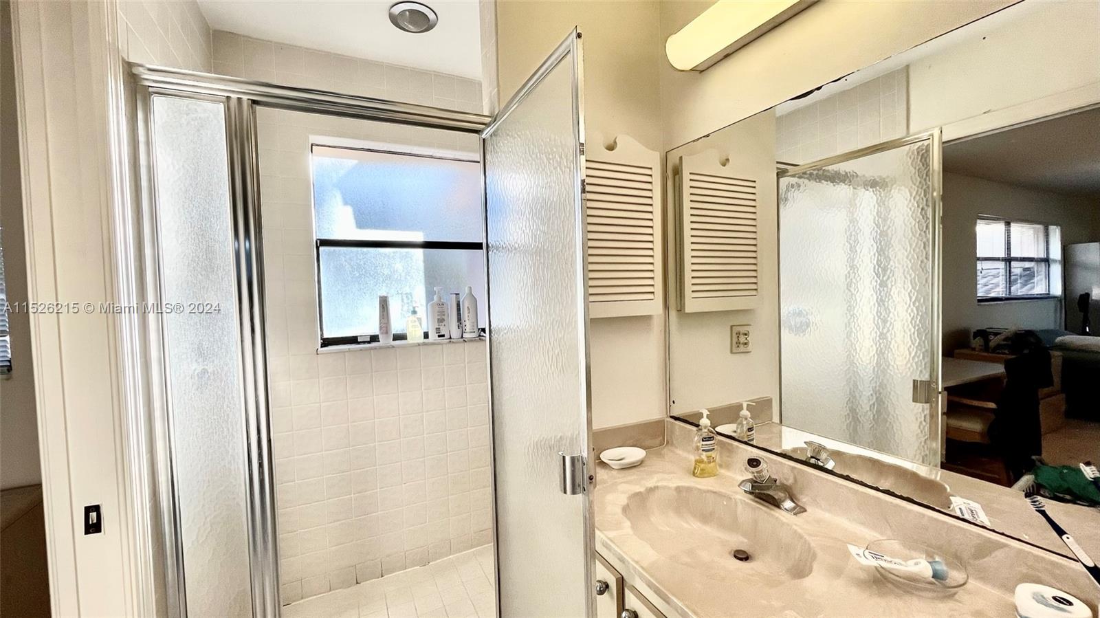 a master bathroom with his-and-her sinks, a walk-in shower, and a tub