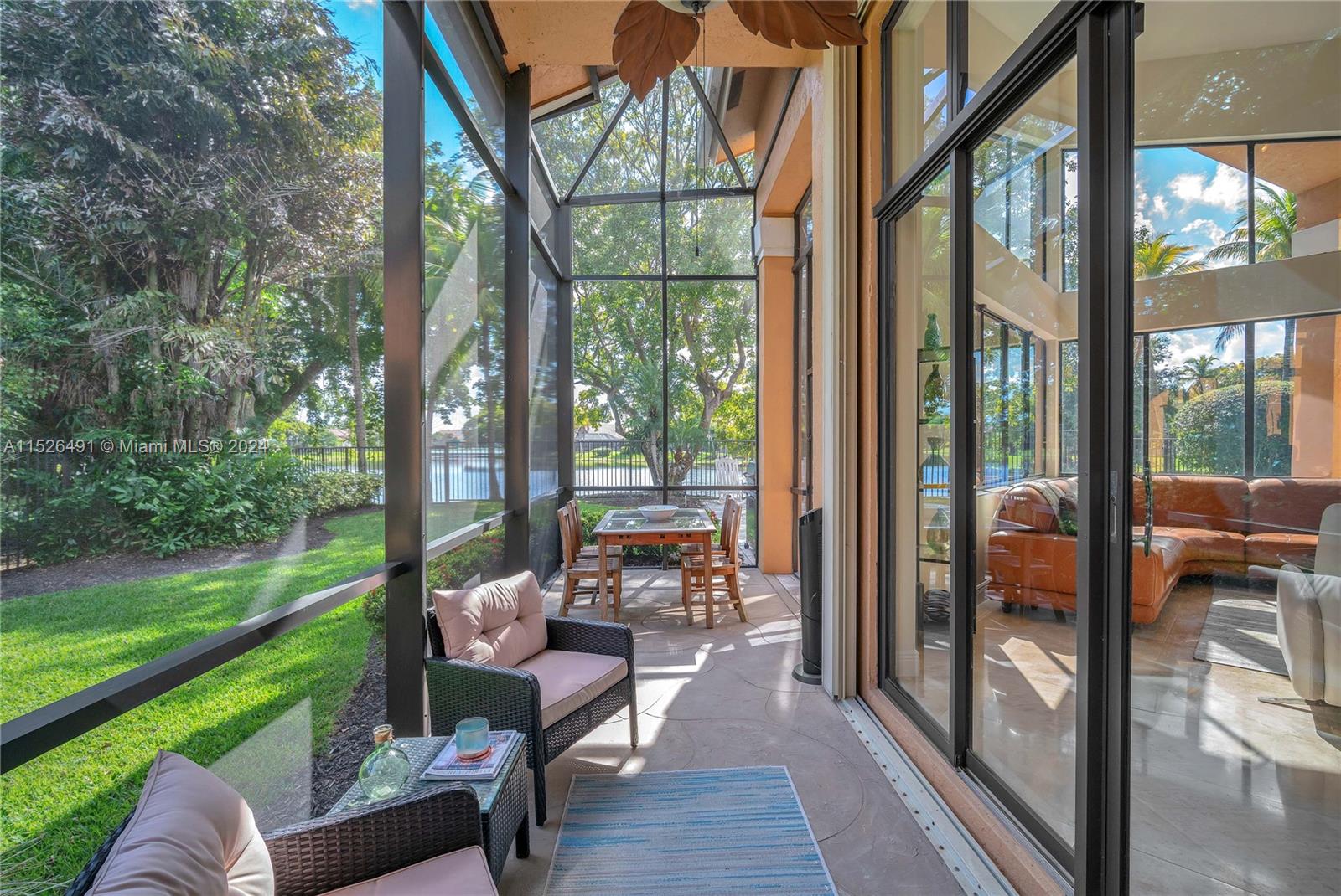 Fully screened covered patio with TV overlooking the lake and pool