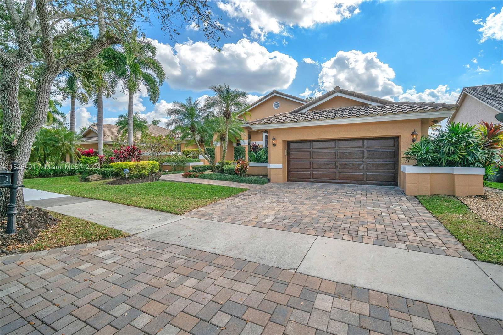 Brick pavered driveway, beautiful manicured landscaping.