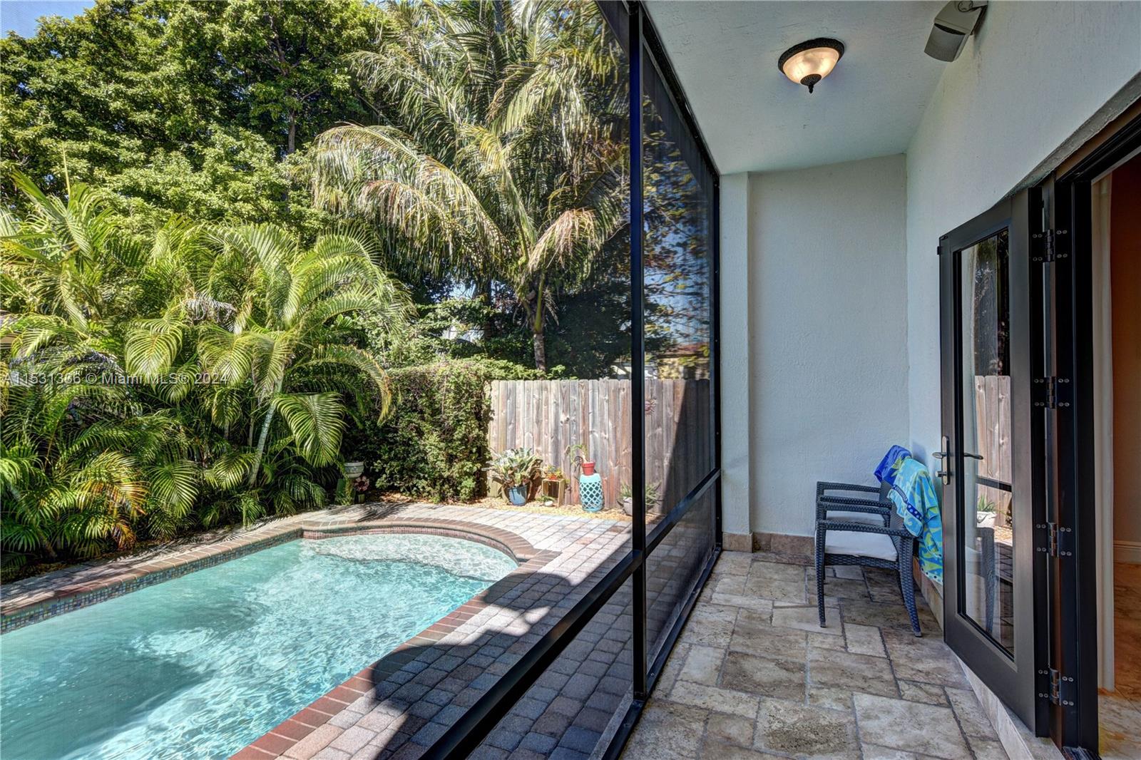 Enclosed porch overlooks the beautiful pool with fountain.
