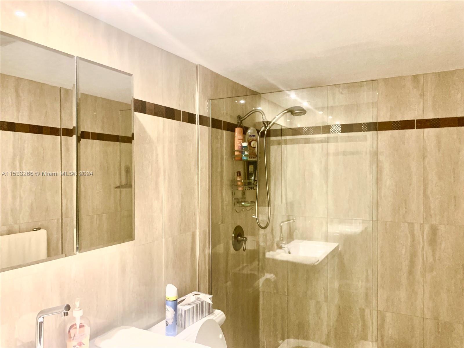 FRAMELESS GLASS SHOWER WITH DESIGNER TILES