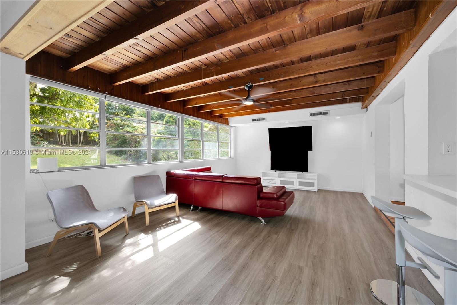 Living Room with open-beam ceiling, banks of windows and exquisite natural light.