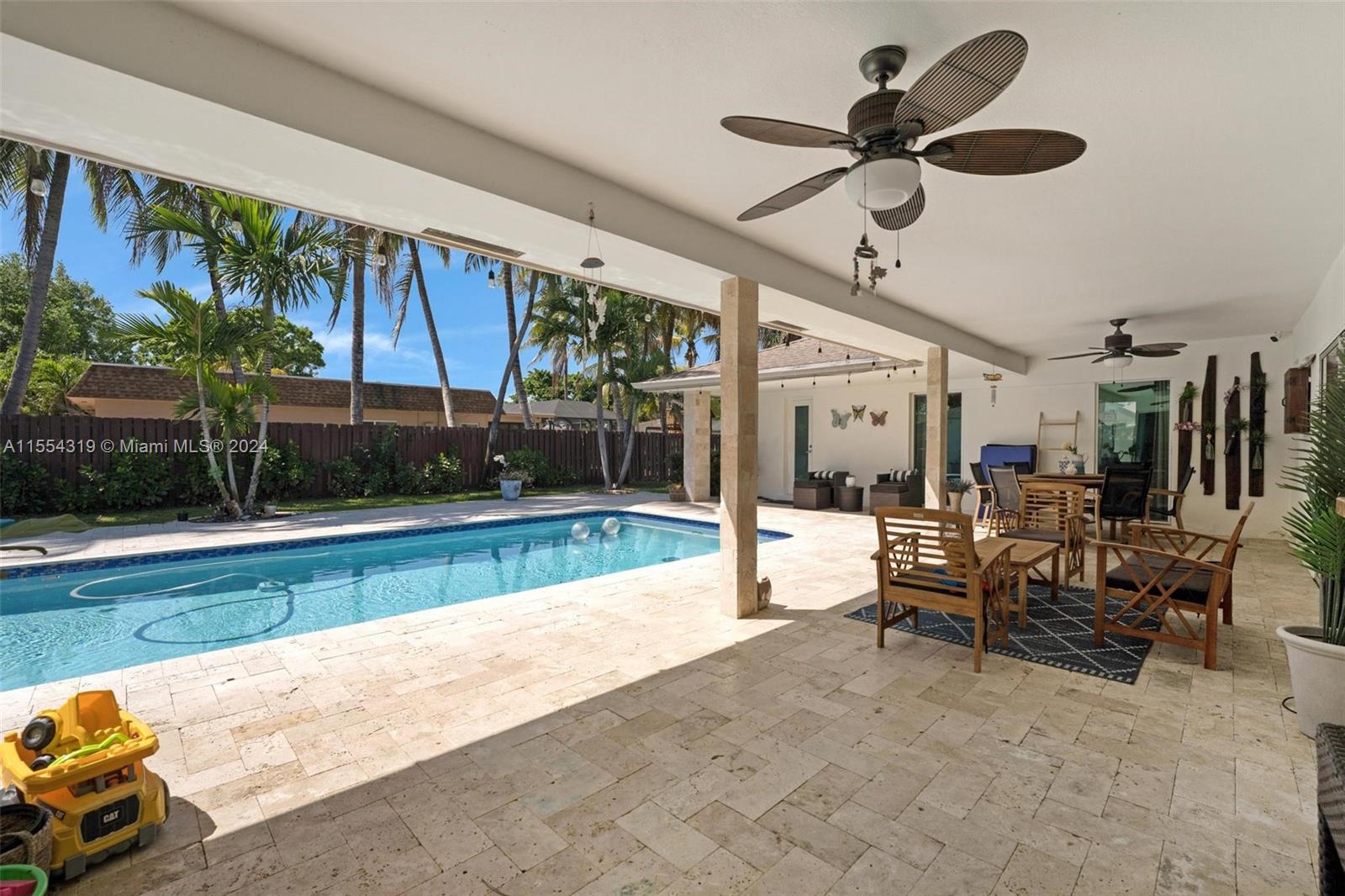 An entertainer's dream, the backyard has multiple entry points from the home. There is a nice covered area with 2 cieling fans perfect for sitting out and enjoy the amazing FL weather.