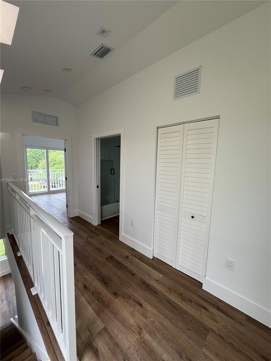 Upstairs hallway with view of 1 upstairs bedroom, bathroom, and laundry room
