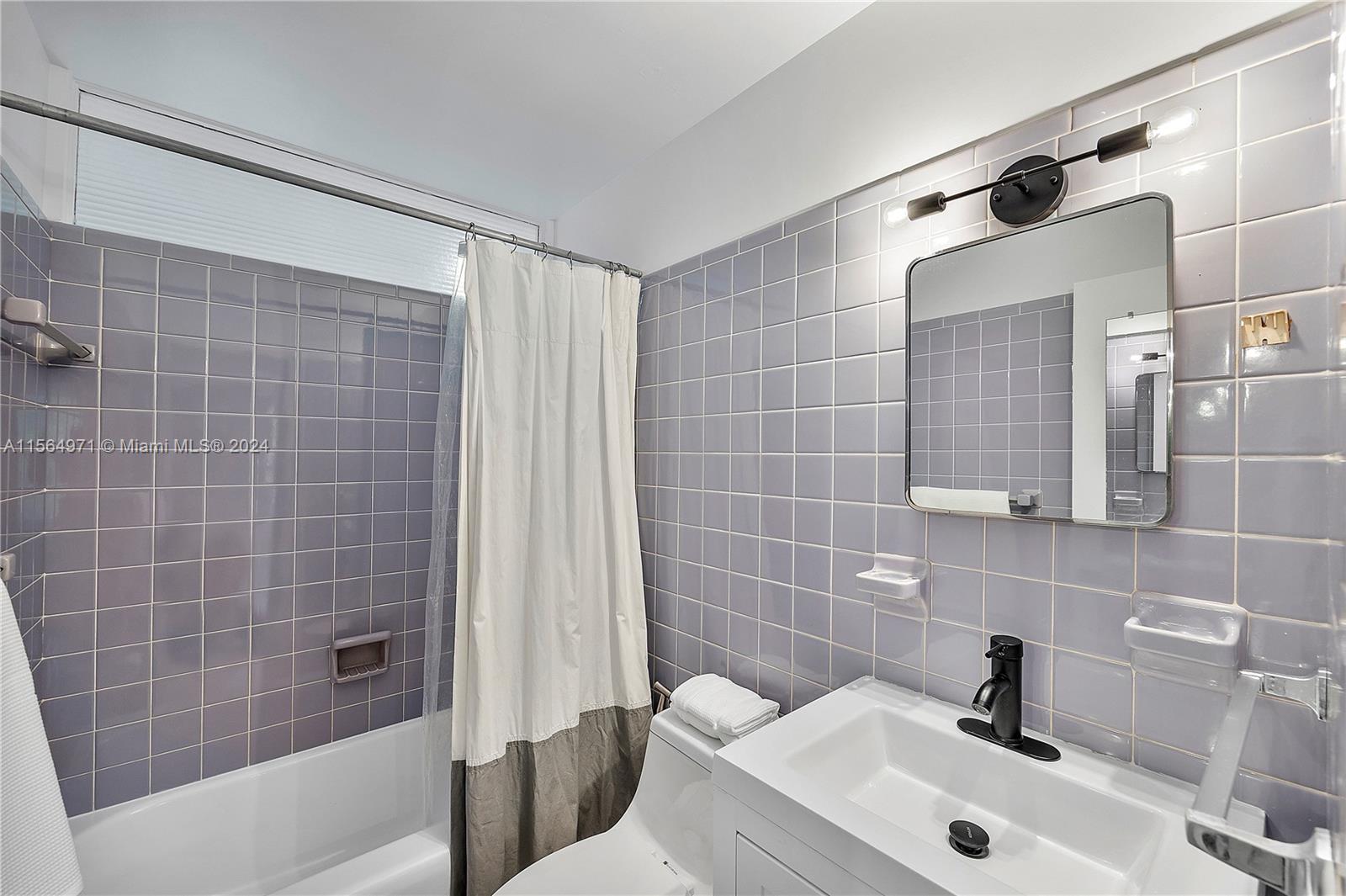 This bathroom features a bathtub, infusing the space with a touch of mid-century charm.