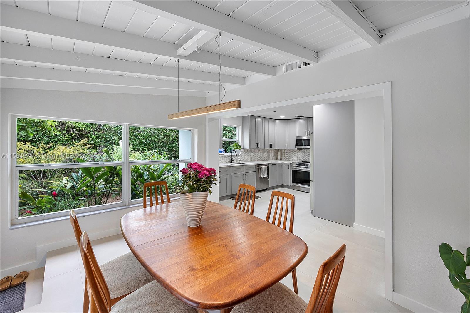 The cozy dining room, practical in its proximity to the open kitchen, offers easy access and delightful views of the garden backyard.
