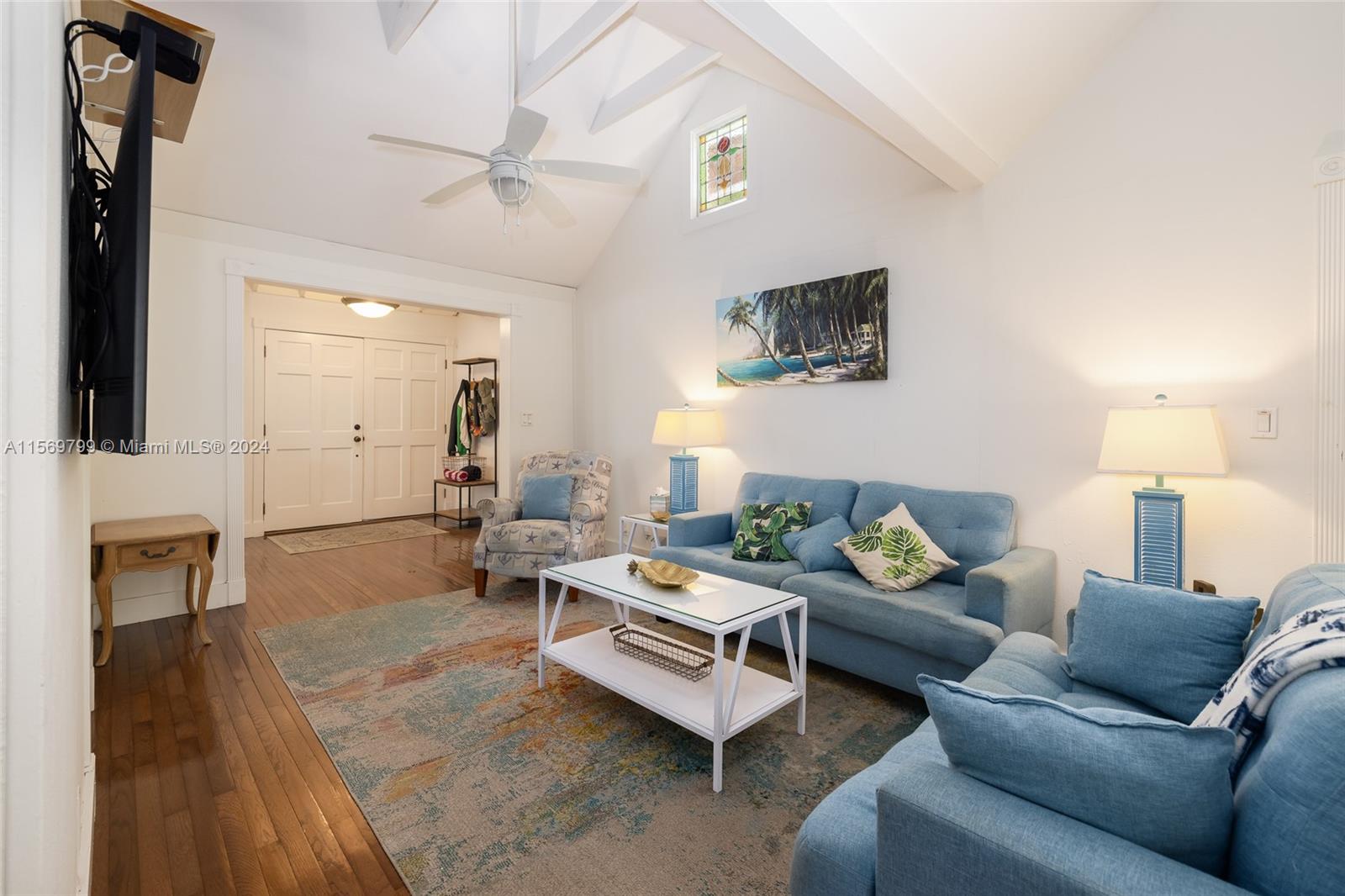 Stunning Living Room with sky-high wood beamed ceiling and gleaming wood floors.