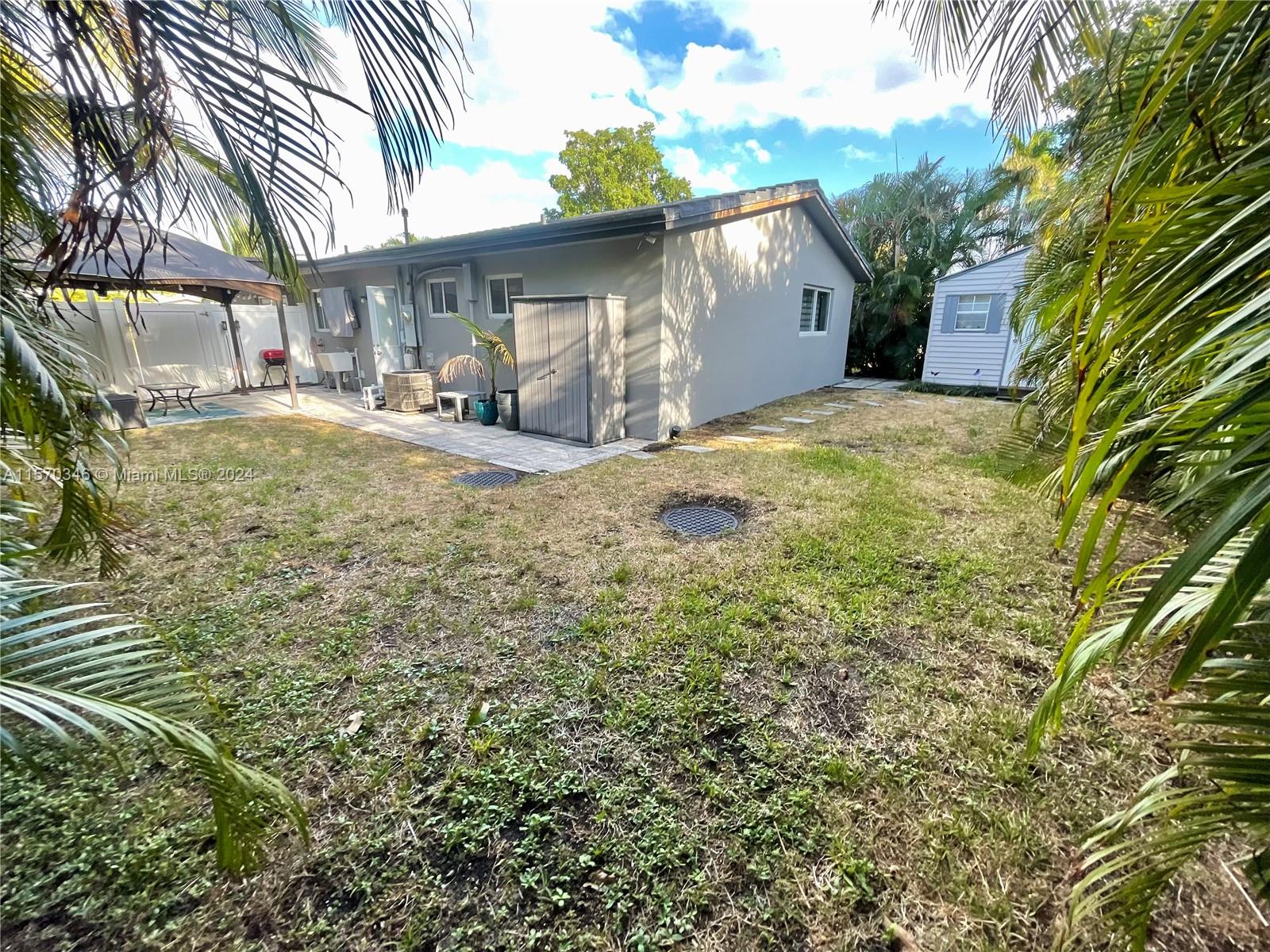 In this secluded haven, surrounded by lush greenery and vibrant palms and ferns, a sense of serenity reigns supreme. The meticulously tended outdoor space invites you to indulge in its carefully crafted beauty, enhanced by the gentle touch of an irrigation sprinkler system ensuring verdant splendor.