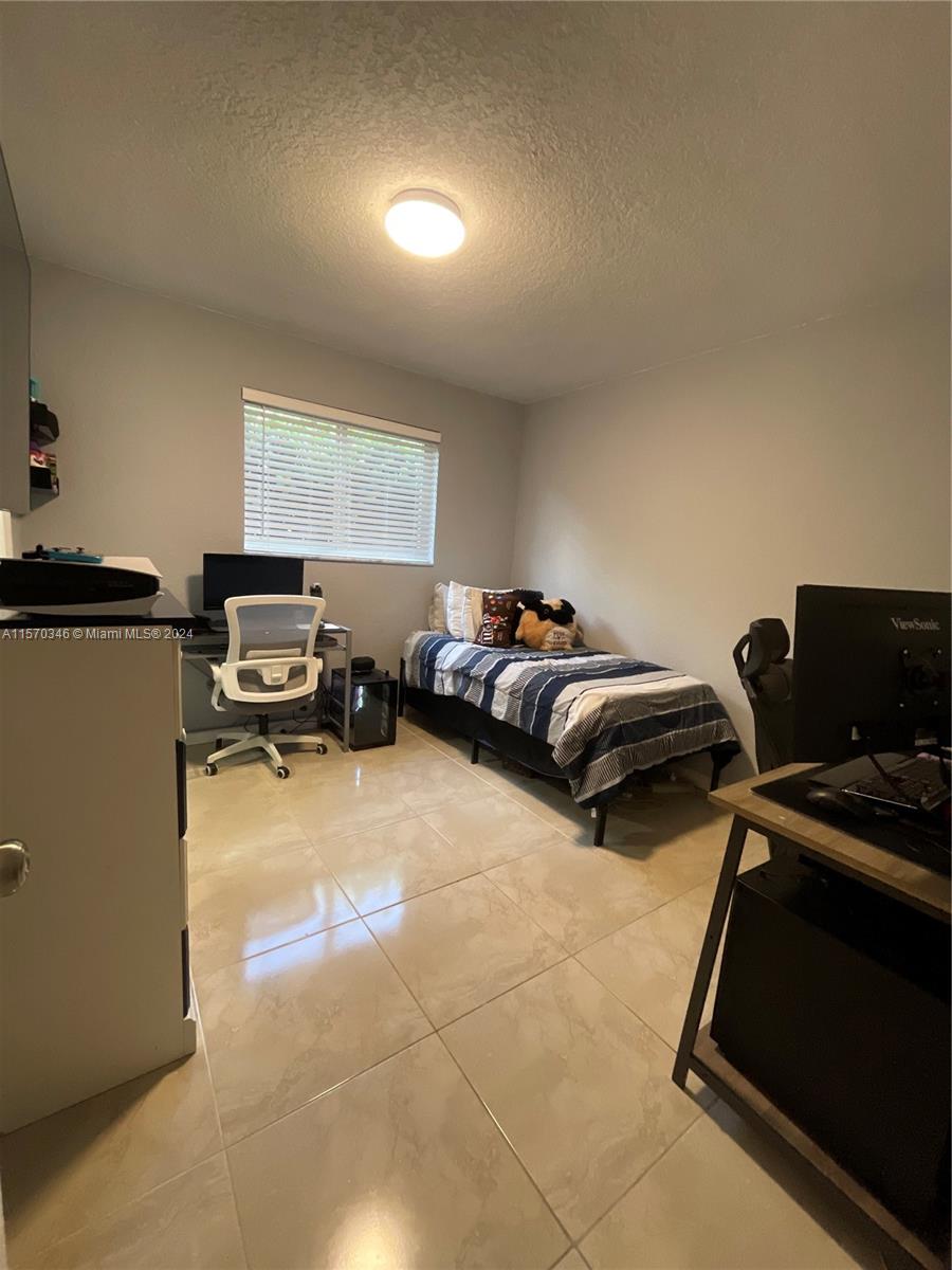 Discover serenity within the expansive confines of bedroom number three, where abundant natural light dances through impact windows, illuminating its stunning tile floors. Delight in the generous proportions of this space, complete with a walking closet featuring a sleek pocket door, seamlessly uniting style with functionality.