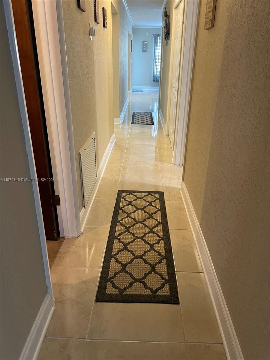 Embark upon a tiled pathway of luminous sophistication, gracefully connecting all three bedrooms and an additional bathroom, seamlessly uniting the entirety of the home with its radiant allure.