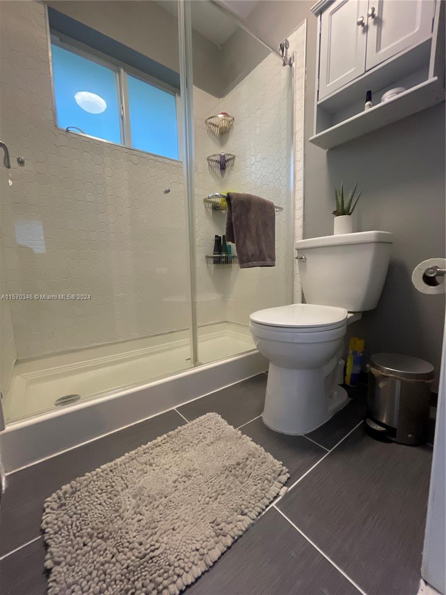 Elegance defines the main suite's bathroom, gracefully separated by barn doors from the vanity area. Sliding glass doors adorn the shower, adding to the luxurious atmosphere of this eloquently updated space.