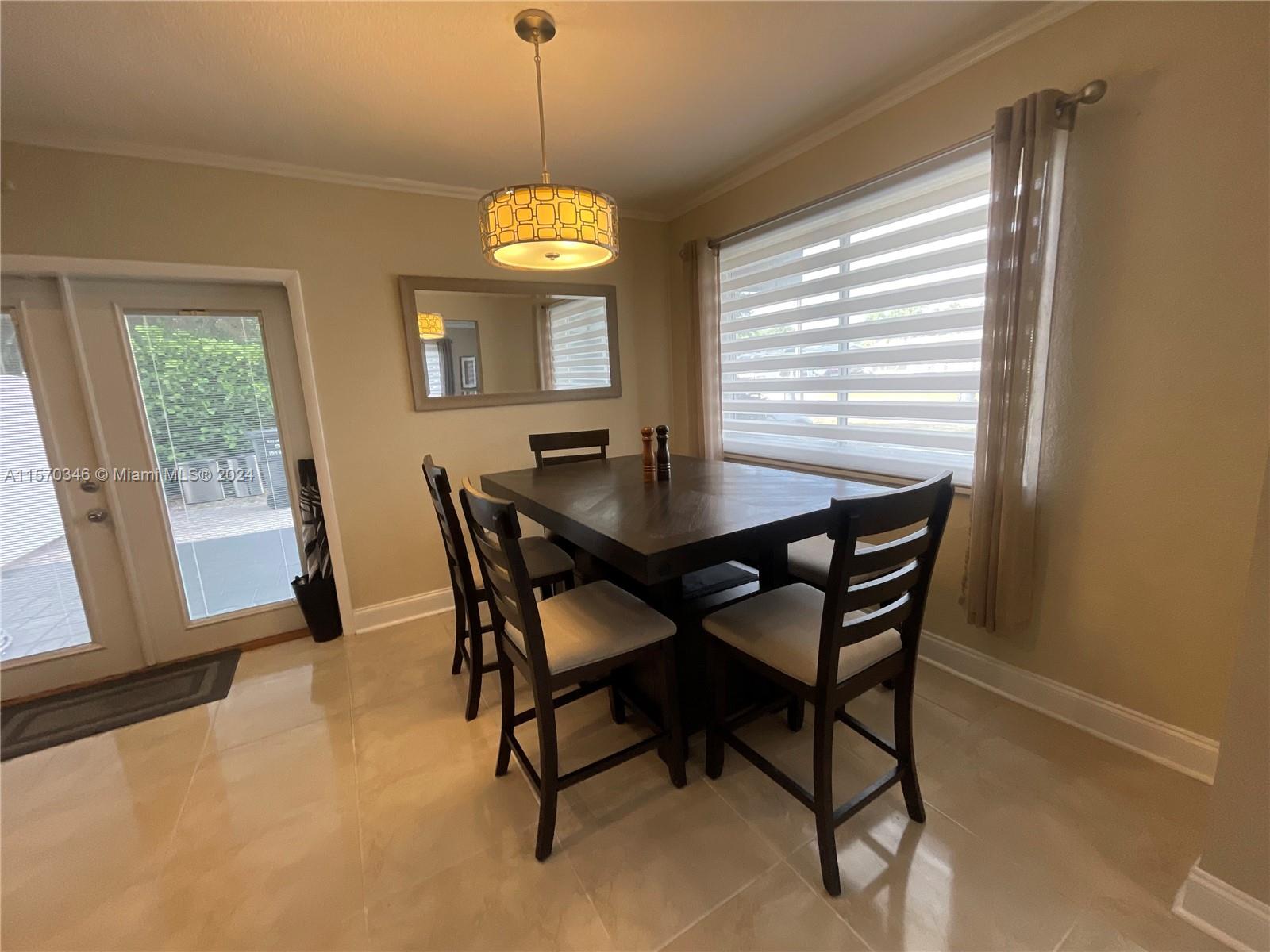 Step into the epitome of seamless entertaining in this sophisticated dining area, seamlessly connecting kitchen, living space, and covered carport via elegant French doors. Effortlessly transition from indoor to outdoor entertainment in your private backyard oasis.