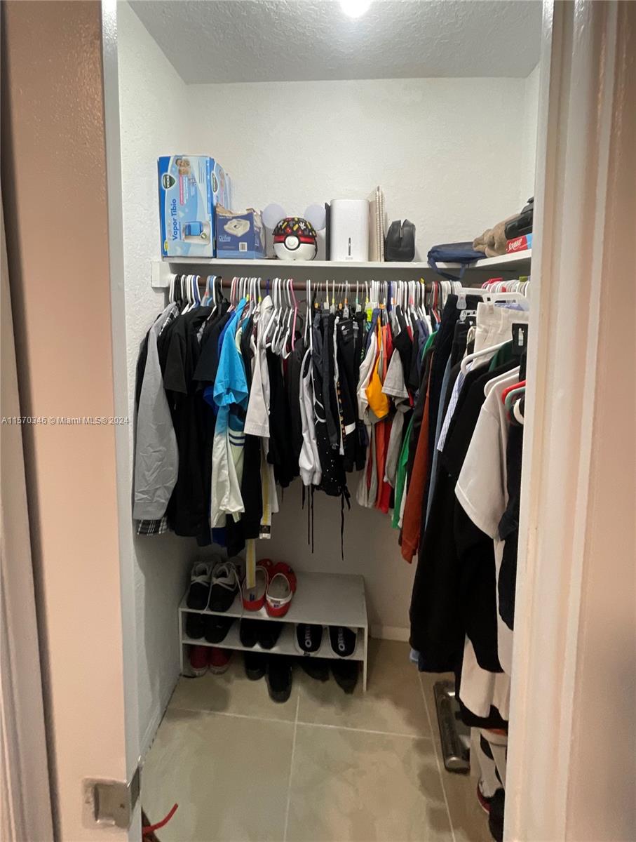 Indulge in luxury with this walk-in closet boasting a convenient pocket door. Ample space and sleek design make organizing a breeze, adding an elegant touch to your daily routine.