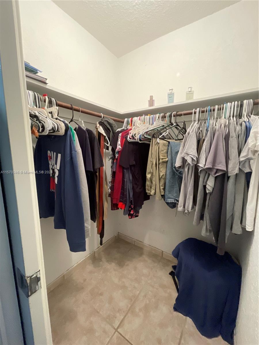 As you stand before it, the expansive walk-in closet boasts opulence, with its grand sliding pocket door and abundant storage space, promising a realm of extravagance and sophistication where every detail speaks to the art of organization and style.
