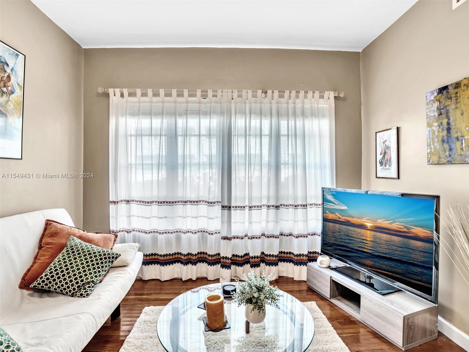Living room with pretty Bay Window .and Wood floors